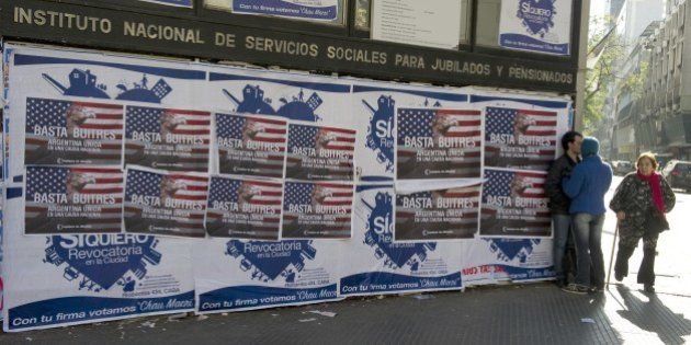 Posters on a wall against the 'vulture funds' in Buenos Aires on June 18, 2014. The US Supreme Court Monday rejected Argentina's appeals against paying at least $1.3 billion to hedge fund investors in its defaulted bonds, piling pressure on the country's finances. Economy Minister Axel Kicillof warned Tuesday that if Argentina implements a new US court ruling against Buenos Aires, it would push the South American nation into default. The posters read 'Enough Vultures - Argentine united in a national cause' AFP PHOTO/ALEJANDRO PAGNI (Photo credit should read ALEJANDRO PAGNI/AFP/Getty Images)