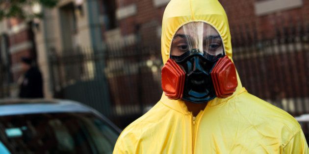 NEW YORK, NY - OCTOBER 25: A young man, dressed in a biohazard costume, stands on the corner of 546 West 147th Street on October 25, 2014 in New York City. After returning to New York City from Guinea, where he was working with Doctors Without Borders treating Ebola patients, Dr. Craig Spencer was quarantined after showing symptoms consistent with the virus. Spencer was taken to Bellevue hospital to undergo testing where he was officially diagnosed with the Ebola virus on October 23. (Photo by Bryan Thomas/Getty Images)