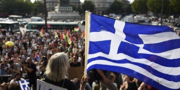 A protester holds a Greek flag as she takes part in a rally in support of the people of Greece at the 'Place de la Bastille' in Paris on July 2, 2015, as Greeks prepare to vote in a referendum on bailout conditions on July 5. AFP PHOTO / LOIC VENANCE (Photo credit should read LOIC VENANCE/AFP/Getty Images)