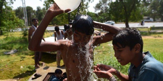 Pakistani youth cool themselves with water during a heat wave in Islamabad on June 21, 2015. At least 17 people have died as a heat wave has gripped the country, local media reported. AFP PHOTO / Farooq NAEEM (Photo credit should read FAROOQ NAEEM/AFP/Getty Images)