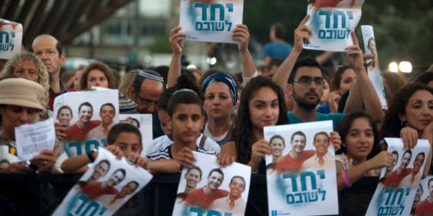 TEL AVIV, ISRAEL - JUNE 29: (ISRAEL OUT) Israelis hold a poster showing the three missing Israeli teenagers, as they attend a rally under the slogan 'Bring Our Boys Home' on June 29, 2014 in Tel Aviv, Israel.Thousands of people gathered in Tel Aviv's Rabin Square on Sunday evening for a rally calling for the release of the three Israeli teens who were kidnapped more than two weeks ago. (Photo by Lior Mizrahi/Getty Images)