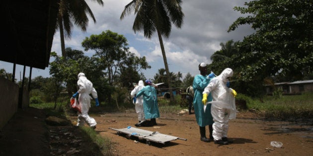 MONROVIA, LIBERIA - OCTOBER 10: An Ebola burial team dresses in protective clothing before collecting the body of a woman, 54, from her home in the New Kru Town suburb on October 10, 2014 of Monrovia, Liberia. The World Health Organization says the Ebola epidemic has now killed more than 4,000 people in West Africa. (Photo by John Moore/Getty Images)