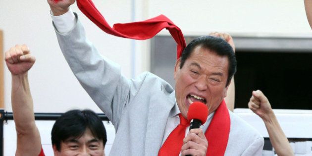 Inoki Antonio, former professional wrestler and a candidate of opposition Japan Restoration Party raises his fist in the air with his supporters after winning in the upper house election at his campaign office in Tokyo on July 21, 2013. The coalition of Japan's Prime Minister Shinzo Abe won a resounding victory in upper house elections. AFP PHOTO / JIJI PRESS JAPAN OUT (Photo credit should read STR/AFP/Getty Images)