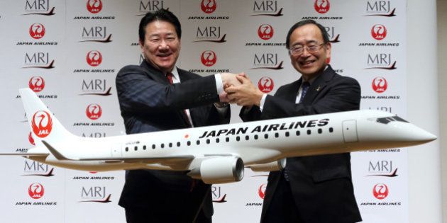 Yoshiharu Ueki, president of Japan Airlines Co. (JAL), left, and Hideo Egawa, chairman and chief executive officer of Mitsubishi Aircraft Corp., shake hands during a news conference in Tokyo, Japan, on Thursday, Aug. 28, 2014. JAL, the country's second-largest airline, agreed to buy 32 planes from Mitsubishi Aircraft to make its fleet more fuel-efficient. Photographer: Tomohiro Ohsumi/Bloomberg via Getty Images