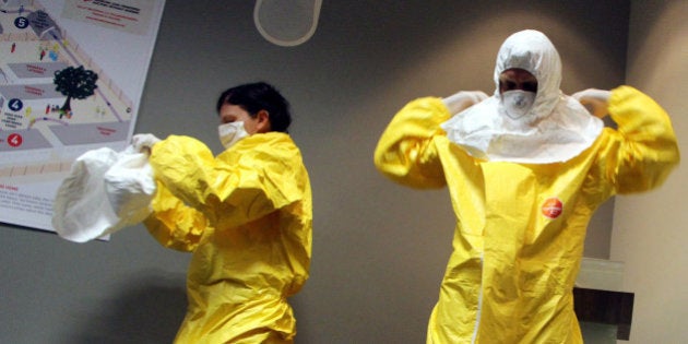 JOHANNESBURG, SOUTH AFRICA - OCTOBER 14: Dr Stefan Kruger and Dr. Juli Switala who have worked with Medecins Sans Frontieres (MSF) show how to put on special uniform to prevent from Ebola virus after they hold press conference in Johannesburg, South Africa, on October 14, 2014. (Photo by Hassan Isilow/Anadolu Agency/Getty Images)