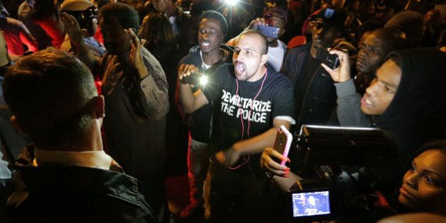 Bassem Masri, center, a man who has live streamed many of the protests in Ferguson, Mo., confronts a St. Louis police officer at the intersection of Shaw Boulevard and Klemm Street as protesters gathered at the scene of a fatal police officer-involved shooting on Wednesday, Oct. 8, 2014. (David Carson/St. Louis Post-Dispatch/MCT via Getty Images)