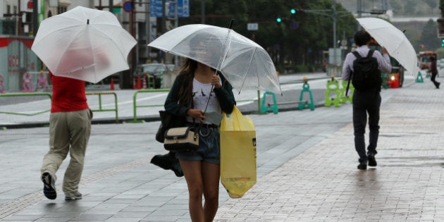 HIMEJI, JAPAN - OCTOBER 13: Pedestrians walk in the wind and rain delivered by Typhoon Vongfong on October 13, 2014 in Himeji, Japan. According to the Japan Meteorological Agency (JMA), Vongfong surpassed Genevieve for the most intense western Pacific typhoon of 2014 by estimated central pressure of 970 hectopascals at its center and packing winds of up to 180 kilometers per hour. Local media reported at least 44 people were injured in typhoon-related accidents, while Japanese airlines cancelled at least 329 flights. JMA has issued the high aleart for heavy rainfall as well as strong winds and waves. Over 80 people deaths following three previous typhoons and torrential rain in Japan this year (Photo by Buddhika Weerasinghe/Getty Images)