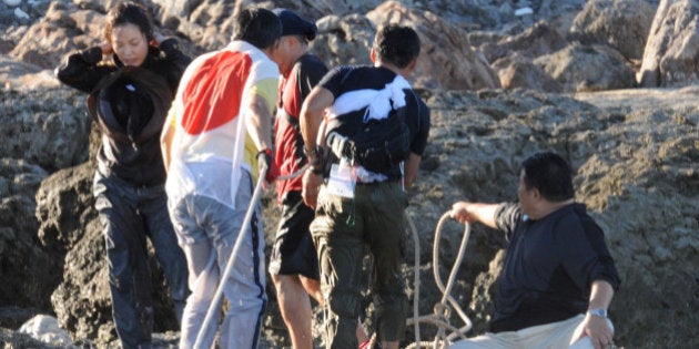 Japanese activists land on a group of islands known as Senkaku in Japanese and Diaoyu in Chinese, early on August 19, 2012 after swimming ashore from a flotilla of ships. Around a dozen members of the right wing group Gambare Nippon (Hang In There Japan) swam ashore, an AFP journalist witnessed, from a 20-boat flotilla carrying activists and lawmakers, raising the flags on the island at the heart of a corrosive territorial row with China in a move likely to further inflame tensions with Beijing. AFP PHOTO / Antoine Bouthier (Photo credit should read ANTOINE BOUTHIER/AFP/GettyImages)