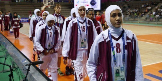 This photo taken on September 24, 2014 shows members of the Qatar women's basketball team walking off the court after withdrawing ahead of their women's preliminary round match against Mongolia during the 17th Asian Games at the Hwaseong Sports Complex Gymnasium in Incheon. Qatar on September 24 withdrew their women's basketball team from the Asian Games just before their first match over a rule banning Muslim headscarves. Qatar and the Olympic Council of Asia (OCA) hit out at the International Basketball Federation (FIBA) rule which bans all headwear on safety grounds. QATAR OUT AFP PHOTO / AL-WATAN DOHA / KARIM JAAFAR (Photo credit should read KARIM JAAFAR/AFP/Getty Images)
