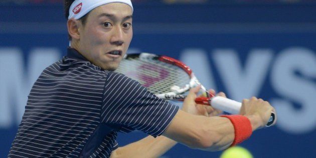 Kei Nishikori of Japan eyes a return against Julien Benneteau of France in the men's singles final at the ATP Malaysia Open tennis tournament in Kuala Lumpur on September 28, 2014. AFP PHOTO / MOHD RASFAN (Photo credit should read MOHD RASFAN/AFP/Getty Images)