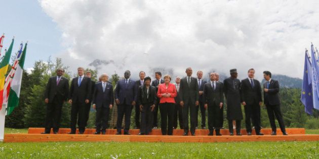 German Chancellor Angela Merkel, center left, speaks with U.S. President Barack Obama, center right, during a group photo of G-7 leaders and Outreach guests at the G-7 summit at Schloss Elmau hotel near Garmisch-Partenkirchen, southern Germany, Monday, June 8, 2015. G-7 leaders, in a second and final day of the conference, were set to tackle the difficult issue of climate change and fighting terrorism. Front row left to right, Ethiopian President Hailemariam Desalegn, Canadian Prime Minister Stephen Harper, Tunisian President Beji Caid Essebsi, Senegal President Macky Sall, Liberian President Ellen Johnson Sirleaf, French President Francois Hollande, Nigerian President Muhammadu Buhari, British Prime Minister David Cameron, Japanese Prime Minister Shinzo Abe. (AP Photo/Markus Schreiber)