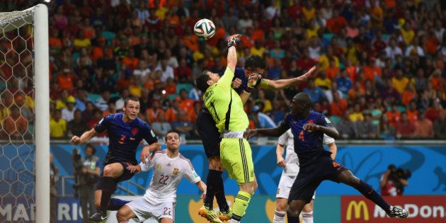 SALVADOR, BRAZIL - JUNE 13: Iker Casillas of Spain and Robin van Persie of the Netherlands collide in the air as the ball carries to Stefan de Vrij of the Netherlands during the 2014 FIFA World Cup Brazil Group B match between Spain and Netherlands at Arena Fonte Nova on June 13, 2014 in Salvador, Brazil. De Vrij scored his teams third goal as a result. (Photo by David Ramos/Getty Images)