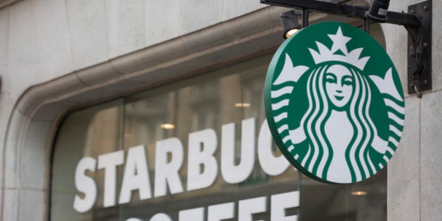 The Starbucks Corp. logo hangs outside of a coffee shop in London, U.K., on Monday, June 9, 2014. U.K. services companies' confidence rose to a record this quarter, indicating continued expansion in the largest part of the economy, the Confederation of British Industry said. Photographer: Jason Alden/Bloomberg via Getty Images