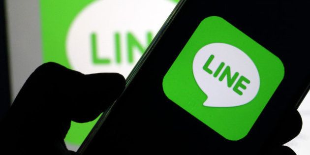 A man uses a smartphone displaying the logo of Line Corp., controlled by Naver Corp., in this arranged...