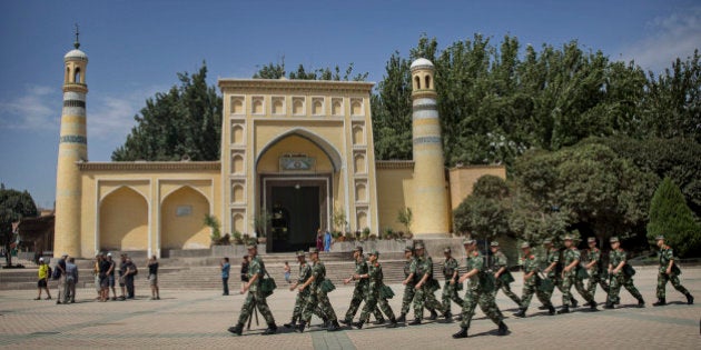 KASHGAR, CHINA - JULY 31: Chinese soldiers march in front of the Id Kah Mosque, China's largest, on July 31, 2014 in Kashgar, China. China has increased security in many parts of the restive Xinjiang Uyghur Autonomous Region following some of the worst violence in months in the Uyghur dominated area. (Photo by Getty Images)