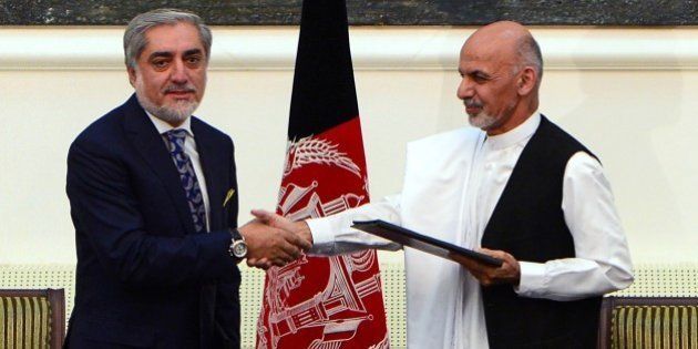 Afghan presidential candidates Abdullah Abdullah (L) and Ashraf Ghani Ahmadzai shake hands after signing a power-sharing agreement at the Presidential Palace in Kabul on September 21, 2014. Afghanistan's two rival presidential candidates signed a power-sharing deal on September 21, ending a prolonged stand-off over disputed election results at a pivotal moment in the war-weary nation's history. AFP PHOTO/Wakil Kohsar (Photo credit should read WAKIL KOHSAR/AFP/Getty Images)