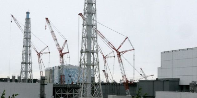 Cranes operate at Unit 3, center, standing next to Unit 4, right, at Tokyo Electric Power Co.'s (Tepco) Fukushima Dai-ichi nuclear power plant in Okuma, Fukushima Prefecture, Japan, on Wednesday, July 9, 2014. All of Japan's 48 operable commercial reactors are idled for safety assessments after the accident at the Fukushima plant. Photographer: Kimimasa Mayama/Pool via Bloomberg