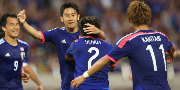 SAITAMA, JAPAN - MAY 27: (EDITORIAL USE ONLY) Shinji Kagawa of Japan congratulates Atsuto Uchida after he scored a goal during the Kirin Challenge Cup international friendly match between Japan and Cyprus at Saitama Stadium on May 27, 2014 in Saitama, Japan. (Photo by Mark Kolbe/Getty Images)