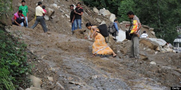 Residents make their way along a damaged roadway to Sonprayag on July 2, 2013, in a flood affected area of the northern Indian state of Uttrakhand. Construction along river banks will be banned in a devastated north Indian state amid concerns unchecked development fuelled last month's flash floods and landslides that killed thousands, the state's top official said. The Chief Minister of Uttarakhand, Vijay Bahuguna, also announced that a regulatory body would be set up to scrutinise future construction as the Himalayan state begins the herculean task of rebuilding following the June 15 floods. AFP PHOTO/SAJJAD HUSSAIN (Photo credit should read SAJJAD HUSSAIN/AFP/Getty Images)