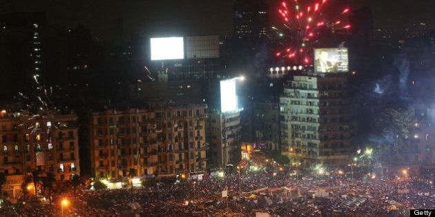 CAIRO, EGYPT - JULY 03: Fireworks and shouts of joy emanate from Tahrir Square after a broadcast by the head of the Egyptian military confirming that they will temporarily be taking over from the country's first democratically elected president Mohammed Morsi on July 3, 2013 in Cairo, Egypt. As unrest spreads throughout the country, at least 23 people were killed in Cairo on Tuesday and over 200 others were injured. It has been reported that the military has taken over the state television. (Photo by Spencer Platt/Getty Images)