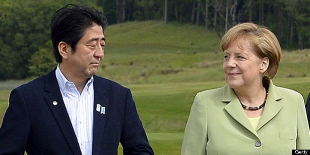 G8 leaders Japan's Prime Minister Shinzo Abe (L) Germany's Chancellor Angela Merkel (C) and Russia's President Vladimir Putin, pose on the podium for the family photograph on the second day of the G8 summit at the Lough Erne resort near Enniskillen in Northern Ireland on June 18, 2013. Russia and the US agreed at the G8 summit to push for Syria peace talks, but Presidents Vladimir Putin and Barack Obama made clear their deep differences over the conflict. AFP Photo/Jewel SAMAD (Photo credit should read JEWEL SAMAD/AFP/Getty Images)