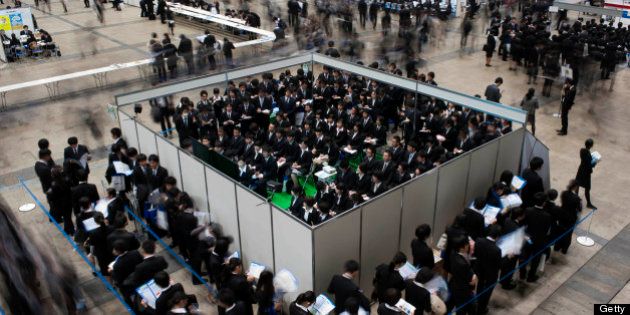 University students attend a job fair hosted by Recruit Co. at Makuhari Messe in Chiba City, Japan, on Sunday, Dec. 11, 2011. Japan's economy grew less than the government's initial estimate last quarter as companies reduced investment on concern overseas demand was stalling. Photographer: Akio Kon/Bloomberg via Getty Images