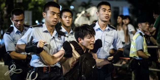 Policemen remove protesters in the central district after a pro-democracy rally seeking greater democracy in Hong Kong early on July 2, 2014 as frustration grows over the influence of Beijing on the city. Scores of protesters were forcibly removed by police in the early hours following a massive pro-democracy rally which organisers said saw a turnout of over half a million. AFP PHOTO / Philippe Lopez (Photo credit should read PHILIPPE LOPEZ/AFP/Getty Images)