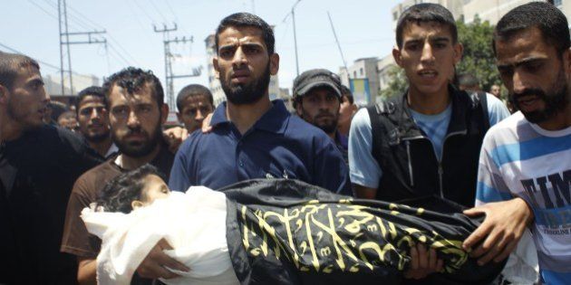 Palestinian mourners carry the body of four-year-old girl Sarah Sheik al-Eid after she was killed along with her father and uncle in a Israeli military strike the previous day, during their funeral in Rafah in the southern Gaza Strip on July 15, 2014 . Israel carried out at least four air strikes against Gaza on Tuesday afternoon, resuming raids after a truce that failed to get off the ground, AFP correspondents and eyewitnesses said. AFP PHOTO/SAID KHATIB (Photo credit should read SAID KHATIB/AFP/Getty Images)