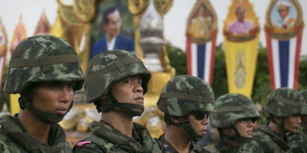BANGKOK, THAILAND - MAY 26: Thai military stand guard near portraits honoring Thai King Bhumibol Adulyadej during an anti-coup protests as General Prayuth receives the Royal Endorsement as the military coup leader May 26, 2014 in Bangkok, Thailand. Thailand has seen many months of political unrest and violence which has claimed at least 28 lives. Thailand is known as a country with a very unstable political record, it is now experiencing it's 12th coup with 7 attempted pervious coups. Thailand's coup leaders have detained former Prime Minister Yingluck Shinawatra, along with Cabinet members and other anti-government protest leaders for up to a week. (Photo by Paula Bronstein/Getty Images)