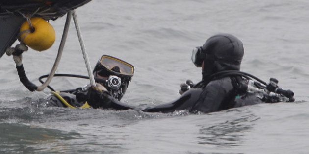 JINDO-GUN, SOUTH KOREA - APRIL 19: Divers with the South Korean Navy search for missing passengers at the site of the sunken ferry off the coast of Jindo Island on April 19, 2014 in Jindo-gun, South Korea. At least twenty nine people are reported dead, with 267 still missing. The ferry identified as the Sewol was transporting about 475 passengers, including students and teachers, travelling to Jeju Island. (Photo by Chung Sung-Jun/Getty Images)