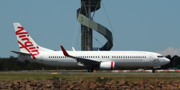 A Boeing Co. 737 aircraft operated by Virgin Australia Holdings Ltd. taxis on the runway at Sydney Airport in Sydney, Australia, on Friday, Dec. 6, 2013. Qantas Airways Ltd.'s credit rating was cut to junk at Standard & Poor's a day after the carrier flagged a record first-half loss and 1,000 job cuts. Photographer: Brendon Thorne/Bloomberg via Getty Images