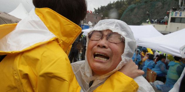 JINDO-GUN, SOUTH KOREA - APRIL 17: A relative weeps as she waits for missing passengers of a sunken ferry at Jindo port on April 17, 2014 in Jindo-gun, South Korea. At least six people are reported dead, with 290 still missing. The ferry identified as the Sewol was carrying about 470 passengers, including students and teachers, traveling to Jeju Island. (Photo by Chung Sung-Jun/Getty Images)