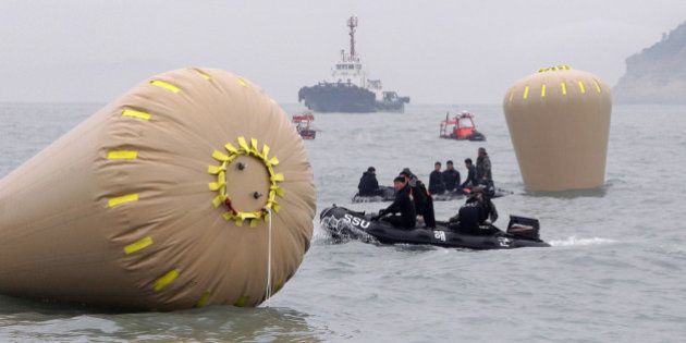 JINDO-GUN, SOUTH KOREA - APRIL 18: South Korean Navy rescue teams work near to the buoys installed to mark the position of the sunken ferry on April 18, 2014 in Jindo-gun, South Korea. At least twenty eight people are reported dead, with 268 still missing. The ferry identified as the Sewol was transporting about 475 passengers, including students and teachers, travelling to Jeju Island. (Photo by Chung Sung-Jun/Getty Images)