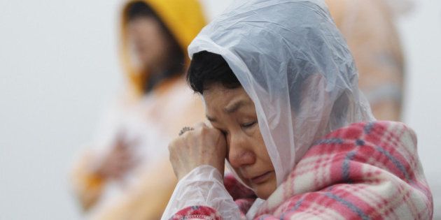 JINDO-GUN, SOUTH KOREA - APRIL 18: A relative weeps as she waits for missing passengers of a sunken ferry at Jindo port on April 18, 2014 in Jindo-gun, South Korea. At least twenty five people are reported dead, with 290 still missing. The ferry identified as the Sewol was carrying about 470 passengers, including the students and teachers, traveling to Jeju Island. (Photo by Chung Sung-Jun/Getty Images)