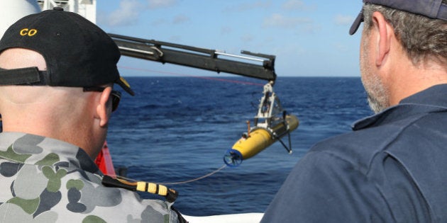 AT SEA - APRIL 17: In this handout image provided by Commonwealth of Australia, Department of Defence, Commander James Lybrand Mission Commander ADV Ocean Shield (L)and Chris 'Sharkie' Moore, Phoenix Team Lead, watch the launching the Phoenix Autonomous Underwater Vehicle (AUV) Artemis off the deck of ADV Ocean Shield on April 17, 2014. Twenty-six nations have been involved in the search for Malaysia Airlines Flight MH370 since it disappeared more than a month ago. The Malaysian Airways aircraft went missing on 8th March 2014 whilst on a flight between Kuala Lumpur and Beijing. (Photo by LSIS Bradley Darvill/Australia Department of Defence via Getty Images)