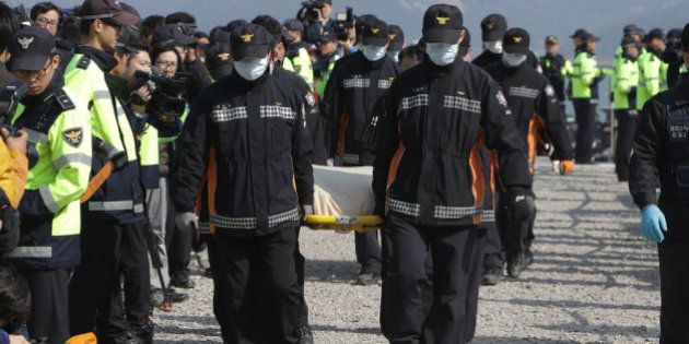 JINDO-GUN, SOUTH KOREA - APRIL 21: Rescue workers carry a victim of the sunken ferry off the coast of Jindo Island on April 21, 2014 in Jindo-gun, South Korea. At least sixty four people are reported dead, with 238 still missing. The ferry identified as the Sewol was carrying about 470 passengers, including the students and teachers, traveling to Jeju Island. (Photo by Chung Sung-Jun/Getty Images)