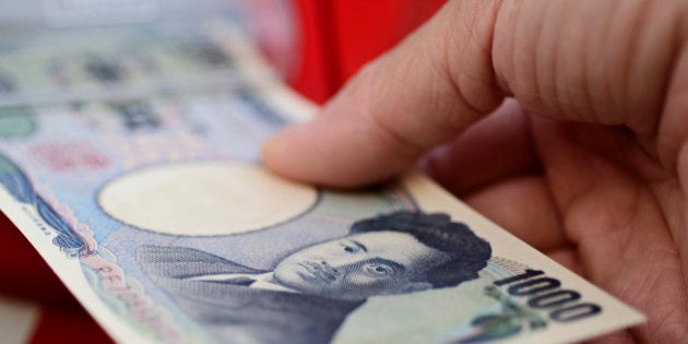 A Japanese 10,000 yen banknote is arranged for a photograph in Kawasaki, Kanagawa Prefecture, Japan, on Tuesday, July 9, 2013. Economists are ditching forecasts for the Bank of Japan to further expand its record easing this year amid signs that a recovering economy may spur inflation. Photographer: Akio Kon/Bloomberg via Getty Images