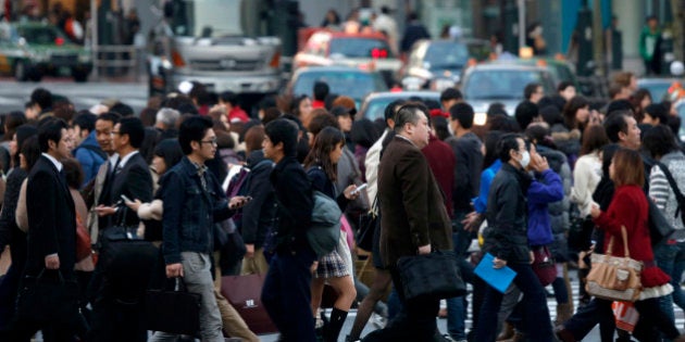 Pedestrians cross an intersection in the Shibuya district of Tokyo, Japan, on Friday, Nov. 22, 2013. Monthly capital inflows into Japanese real estate investment trusts rose to the highest since March 2010 in September amid expectations that the 2020 Olympic Games in Tokyo will help boost the property market and on signs commercial land prices in major cities are rebounding, according to a report by the Association of Real Estate Securitization. Photographer: Kiyoshi Ota/Bloomberg via Getty Images