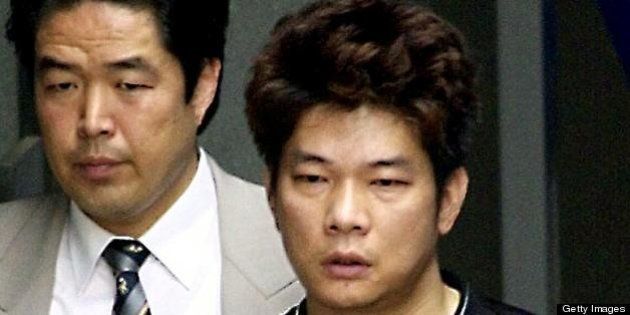 IKEDA, JAPAN: Mamoru Takuma (R), who allegedly stabbed eight children to death in an elementary to school in Ikeda, Osaka Prefecture, on 08 June, leaves Ikeda police station for the Osaka district court 10 June 2001. Takuma, an outpatient at a mental hospital from 1999 to May 2001, is accused of using a 15-centimetre knife to stab 23 people, killing 8 children and injuring 15 people, including two teachers. AFP PHOTO/JIJI PRESS (Photo credit should read AFP/Getty Images)