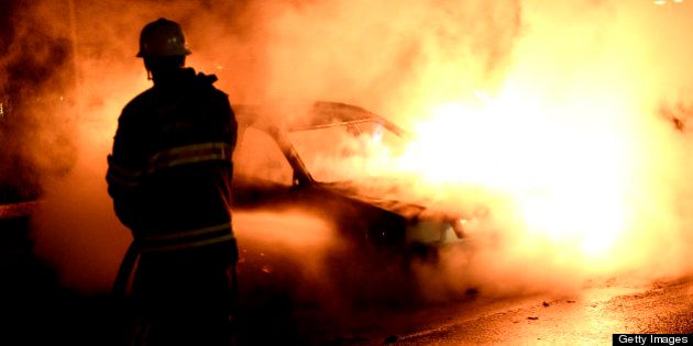 Firemen extinguish a burning car in Kista after youths rioted in few differant suburbs around Stockholm on May 21, 2013. Youths in the immigrant-heavy Stockholm suburb of Husby torched cars and threw rocks at police, in riots believed to be linked to the deadly police shooting of a local resident. AFP PHOTO/JONATHAN NACKSTRAND (Photo credit should read JONATHAN NACKSTRAND/AFP/Getty Images)