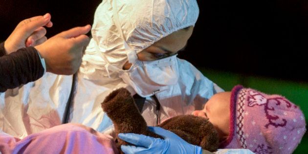 ** ALTERNATE CROP OF ALT101 ** A rescuer cradles a child in the Sicilian harbor of Pozzallo, Italy, early Monday, April 20, 2015. About 100 migrants, including 28 children, were rescued on Sunday by a merchant vessel in the Sicilian Strait while they were trying to cross. Another smuggler's boat crammed with hundreds of people overturned off Libya's coast on Saturday as rescuers approached, causing what could be the Mediterranean's deadliest known migrant tragedy and intensifying pressure on the European Union Sunday to finally meet demands for decisive action. (AP Photo/Alessandra Tarantino)