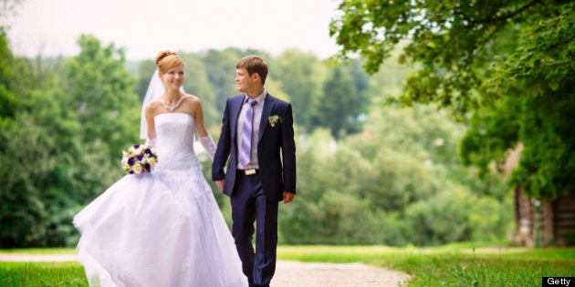 Newly married couple walking down the avenue in the forest