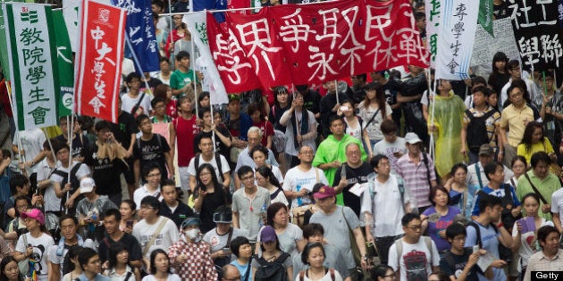 HONG KONG - JULY 01: Thousands of protesters march on July 1, 2013 in Hong Kong. Thousands of protesters march calling for universal suffrage and chanting slogans against Hong Kong Chief Executive C Y Leung when Typhoon Signal No. 3 is hoisted. Hong Kong Special Administrative Region Establishment Day is celebrated every July 1st, in Hong Kong since 1997. (Photo by Lam Yik Fei/Getty Images)