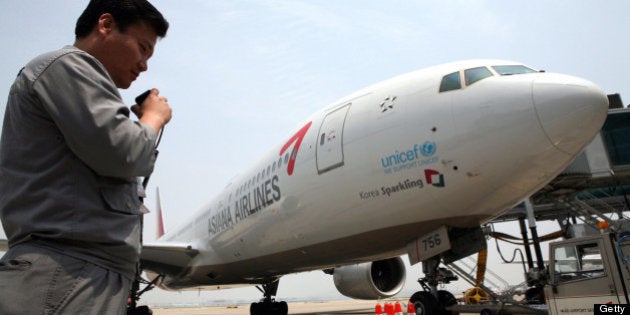 SOUTH KOREA - MAY 22: An airport ground staff member uses his radio as he stands near an Asiana Airlines Inc. passenger jet at Incheon International Airport, in Incheon, South Korea, on Thursday, May 22, 2008. Korean Air Lines Co., South Korea's largest carrier, fell to the lowest in a year in Seoul trading on concern record oil prices may result in losses. Asiana Airlines Inc., the country's second-biggest airline, lost 3.5 percent to 5,720 won. (Photo by Jean Chung/Bloomberg via Getty Images)