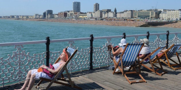 BRIGHTON, ENGLAND - AUGUST 01: People relax in the mini heatwave on the pier at Brighton beach on August 1, 2013 in Brighton, England. A heatwave has returned to much of the country with temperatures expected to reach highs of 32C. (Photo by Mike Hewitt/Getty Images)