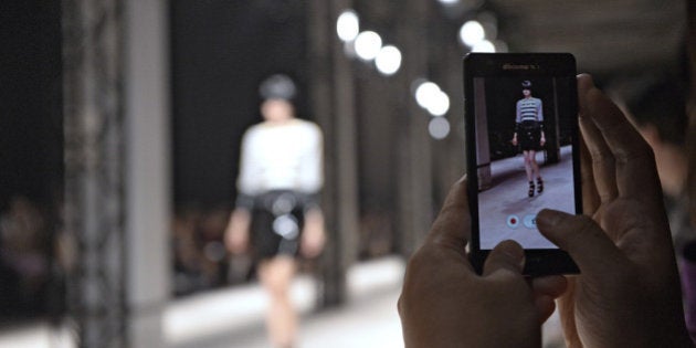 PARIS, FRANCE - SEPTEMBER 25: A model is recorded on smart phones and iPhones as she walks the runway at the Undercover Spring Summer 2014 fashion show during Paris Fashion Week on September 25, 2013 in Paris, France. (Photo by Catwalking/Getty Images)