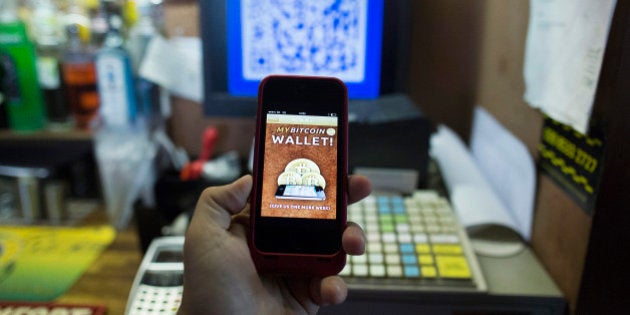 An Apple Inc. iPhone5 displays the Bitcoin smartphone app in this arranged photograph at the bar of the Pembury Tavern in London, U.K., on Wednesday, Oct. 9, 2013. Bitcoins are being adopted by a few merchants, enabling customers to buy beer at Pembury Tavern in East London, cocktails at EVR bar in New York and dessert at Cups and Cakes Bakery in San Francisco. Photographer: Simon Dawson/Bloomberg via Getty Images