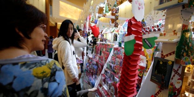 People look at Christmas cards displayed for sale at a stall in a shopping mall in Tokyo, Japan, on Thursday, Dec. 5, 2013. The cabinet approved an 18.6 trillion yen ($182 billion) economic package to cushion the economic blow from a sales-tax increase next April. The package includes 5.5 trillion yen in spending and the government projects it will boost real gross domestic product by about 1 percent and create about 250,000 jobs. Photographer: Kiyoshi Ota/Bloomberg via Getty Images