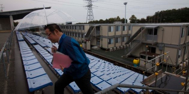A employee of the Tokyo Electric Power Co. walks up stairs near temporary housing built for workers who...
