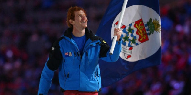 SOCHI, RUSSIA - FEBRUARY 07: Skier Dow Travers of the Cayman Islands Olympic team carries his country's...